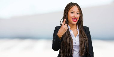 Gösterilen bir numaralı simgesi sayma, kavramı matematik, kendinden emin ve neşeli bir genç siyah iş kadın portresi