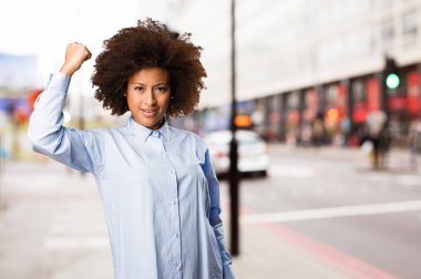 Genç siyah kadının arka plan bulanık güçlü jest yapması