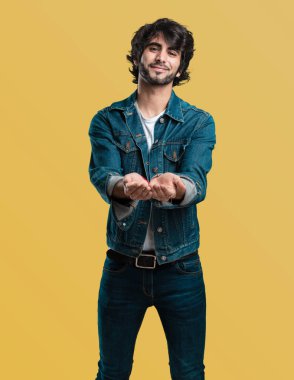 Elleriyle bir şey tutan, bir ürün, gülümseyen ve neşeli gösterilen, hayali bir nesne sunan yakışıklı delikanlı