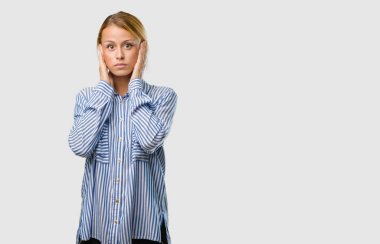 Elleriyle kulaklarını kapsayan genç güzel sarışın kadın portresi