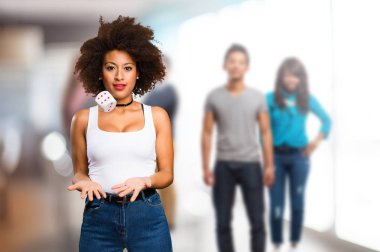 arka plan bulanık insanlarla bir zar ile oynayan genç siyah kadın