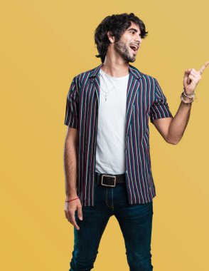 Sürpriz bir şey, doğal ve rahat sunan gülümseyen genç yakışıklı adam tarafına işaret