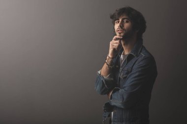 Genç yakışıklı adam neşeli ve kendine güvenen Studio kamera bakıyor 