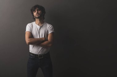 Genç yakışıklı adam neşeli ve kendine güvenen Studio kamera bakıyor 