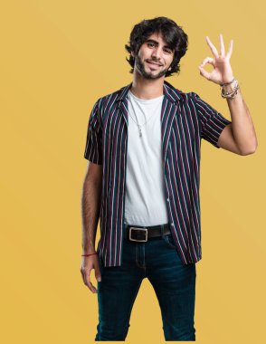 Genç yakışıklı adam neşeli ve kendine güvenen heyecanlı ve çığlık, onay ve başarı kavramı ok jest yapıyor