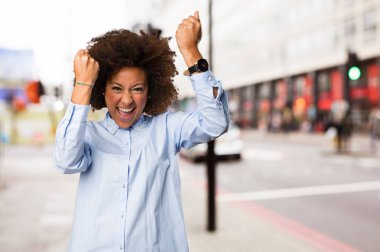 Genç siyah kadının arka plan bulanık kazanan jest yapması