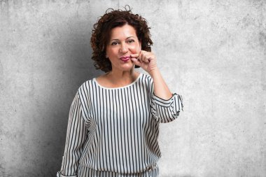 Bir sırrı saklamak veya soran sessizlik, ciddi bir yüz, itaat kavramı için orta yaşlı kadın