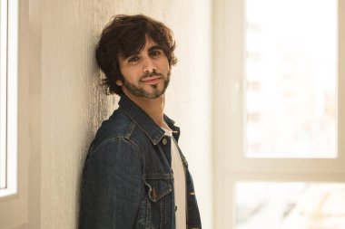 Genç yakışıklı adam neşeli ve kendine güvenen Studio kamera bakıyor 