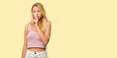 Bir sırrı saklamak veya soran sessizlik, ciddi bir yüz, itaat kavramı için genç güzel sarışın kadın portresi