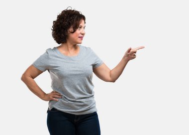 Sürpriz bir şey, doğal ve rahat sunan gülümseyen tarafına işaret orta yaşlı kadın