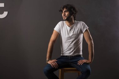 Genç yakışıklı adam neşeli ve kendine güvenen Studio kamera bakıyor 