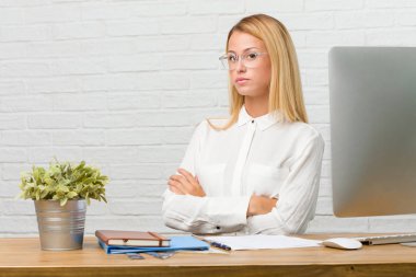 Genç öğrenci ve heybetli, kollarını, ciddi geçiş görevleri yapmak onun masasına oturan kendine güvenen ve göstermek güç hissi portresi