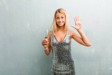 Gösterilen beş numara, sayma sembolü, matematik, kendinden emin ve neşeli kavramı zarif sarışın genç kadın portresi. Bir şampanya kadehi holding.