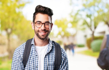 Genç adam bulanık arka plan üzerinde gülümseyen