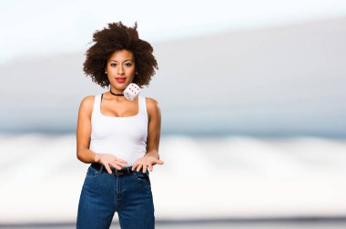 Genç siyah kadın bir zar ile oynarken arka plan bulanık