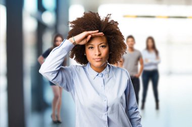 Genç siyah kadın arka planda bulanık insanlarla çok arıyor