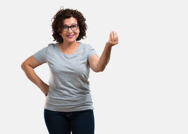 Orta yaşlı kadının bir tipik İtalyan jest, gülümseyen ve dümdüz bakarak, sembol veya el, çok doğal bir ifadeyle yapması