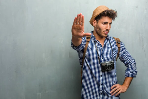 麦わら帽子 バックパックと写真カメラ深刻で決定され 手を入れて停止ジェスチャーを着た若いハンサムな旅行者男拒否概念 — ストック写真