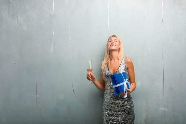 エレガントな若い金髪女性シャンパンを飲むと 贈り物を持って紙吹雪で新年を祝うの肖像画 — ストック写真