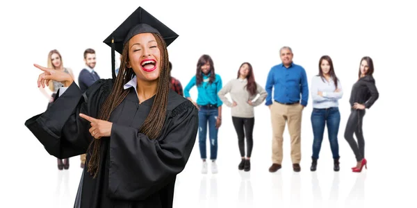 Jovem Graduada Mulher Negra Vestindo Tranças Apontando Para Lado Sorrindo — Fotografia de Stock