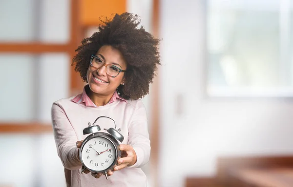 black woman holding alarm clock