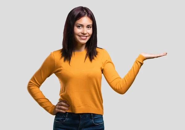 Mulher Bonita Jovem Segurando Algo Com Mãos Mostrando Produto Sorrindo — Fotografia de Stock