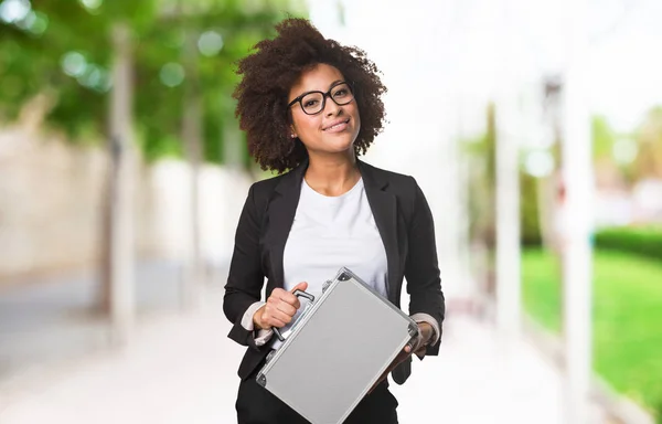 black business woman holding a briefcase on blurred background