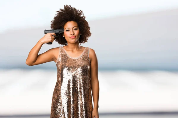 背景をぼかした写真の銃を使用して流行のドレスの若い黒人女性 — ストック写真