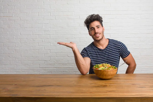 Joven Hombre Guapo Natural Sentado Una Mesa Sosteniendo Algo Con — Foto de Stock