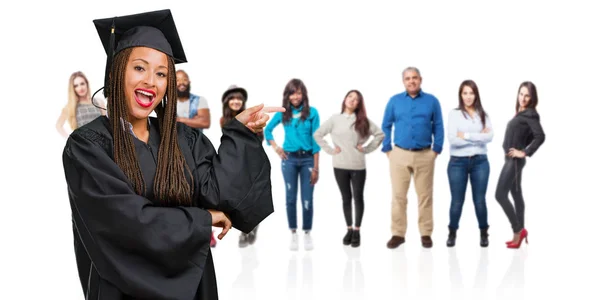 Jovem Graduada Mulher Negra Vestindo Tranças Apontando Para Lado Sorrindo — Fotografia de Stock