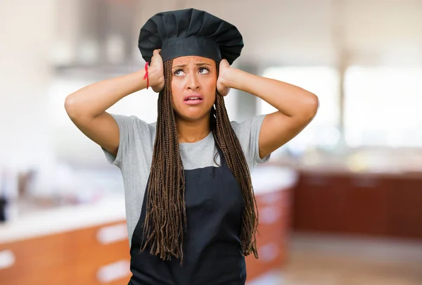 Portrait of a young black baker woman worried and overwhelmed, forgetful, realize something, expression of shock at having made a mistake