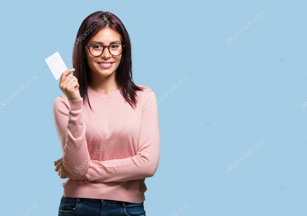 Young pretty woman smiling confident, offering a business card, has a thriving business, copy space to write whatever you want