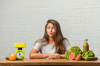 Diyet kavramı. Bir sağlıklı genç latin kadın şüphe ve karışık, düşünme, bir fikir ya da bir şey hakkında endişeli portresi