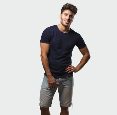 Yakışıklı delikanlı ile ayakta duran, rahat ve gülümseyen, çok olumlu ve neşeli kalçalarına eller