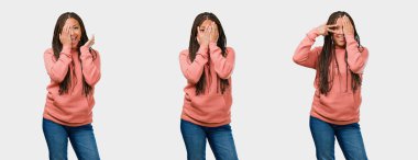 Endişe ve korku, seyir ve gri arka yüzünde kapsayan fitness genç siyah kadın kümesi hissediyor