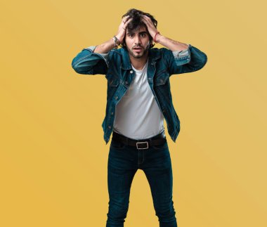 Genç yakışıklı adam sinirli ve umutsuz, kızgın ve üzgün ile ellerinizi başınızın koyun