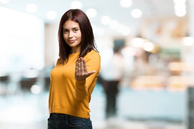 Gel, kendinden emin ve gülümseyen bir hareketi el ile yapmak için davet kadın pozitif ve güler yüzlü bir kafeteryada genç güzel