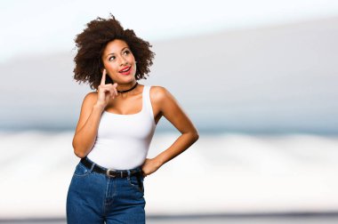 bulanık arka plan üzerinde düşünme genç siyah kadın