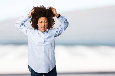 Genç siyah kadının arka plan bulanık deli jest yapması