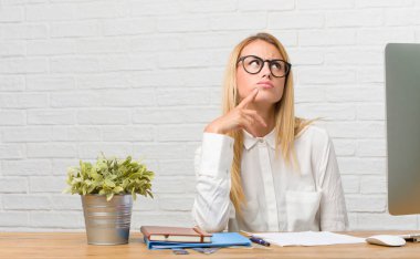 Düşünme ve bakılması, hakkında bir fikir, karışık görevleri yapmak masasına oturan genç öğrenci portresi bir çözüm bulmaya çalışıyorum