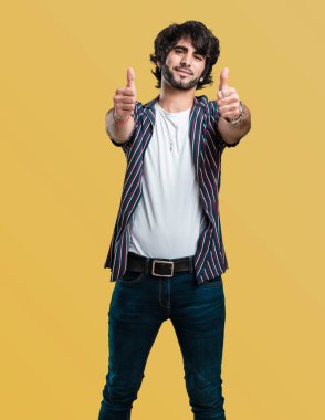 Genç yakışıklı adam neşeli ve heyecanlı, gülümseyerek onu başparmak, başarı ve onay, kavram yükselterek ok ve jest