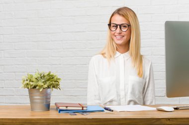 Neşeli ve büyük bir gülümseme ile kendinden emin, samimi ve içten, görevleri yapmak masasına oturan genç öğrenci portresi pozitifliği ve başarı ifade etmek