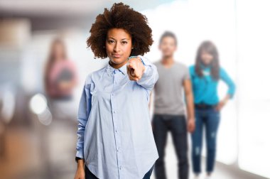 Genç siyah kadın işaret ön planda bulanık insanlarla