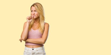 Isırma genç güzel sarışın kadın portresi çivi, gergin ve çok endişeli ve gelecek için korkmuş hissediyor panik ve stres