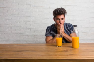 Bir şey söylemek ağız, sessizlik ve baskı, sembolü kapsayan bir masada oturan genç yakışıklı ve doğal adam çalışıyor. Bir kahvaltı yapıyor, portakal suyu ve tahıl bowl içerir.