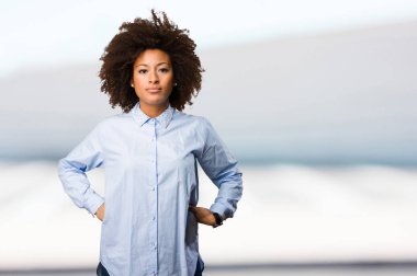 bulanık arka plan üzerinde duran genç siyah kadın