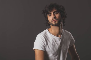 Genç yakışıklı adam neşeli ve kendine güvenen Studio kamera bakıyor 