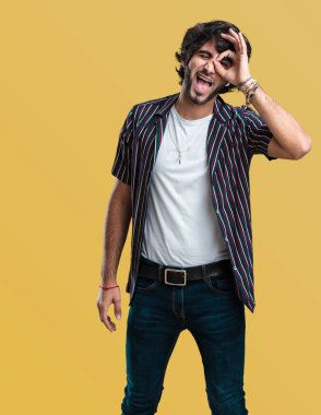 Genç yakışıklı adam neşeli ve kendine güvenen heyecanlı ve çığlık, onay ve başarı kavramı ok jest yapıyor