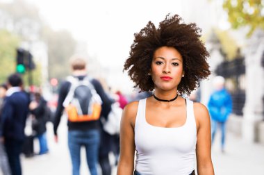 bulanık arka plan üzerinde duran genç siyah kadın