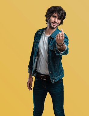 Pozitif ve güler yüzlü genç yakışıklı adam gel, kendinden emin ve gülümseyen bir hareketi el ile yapmak için davet